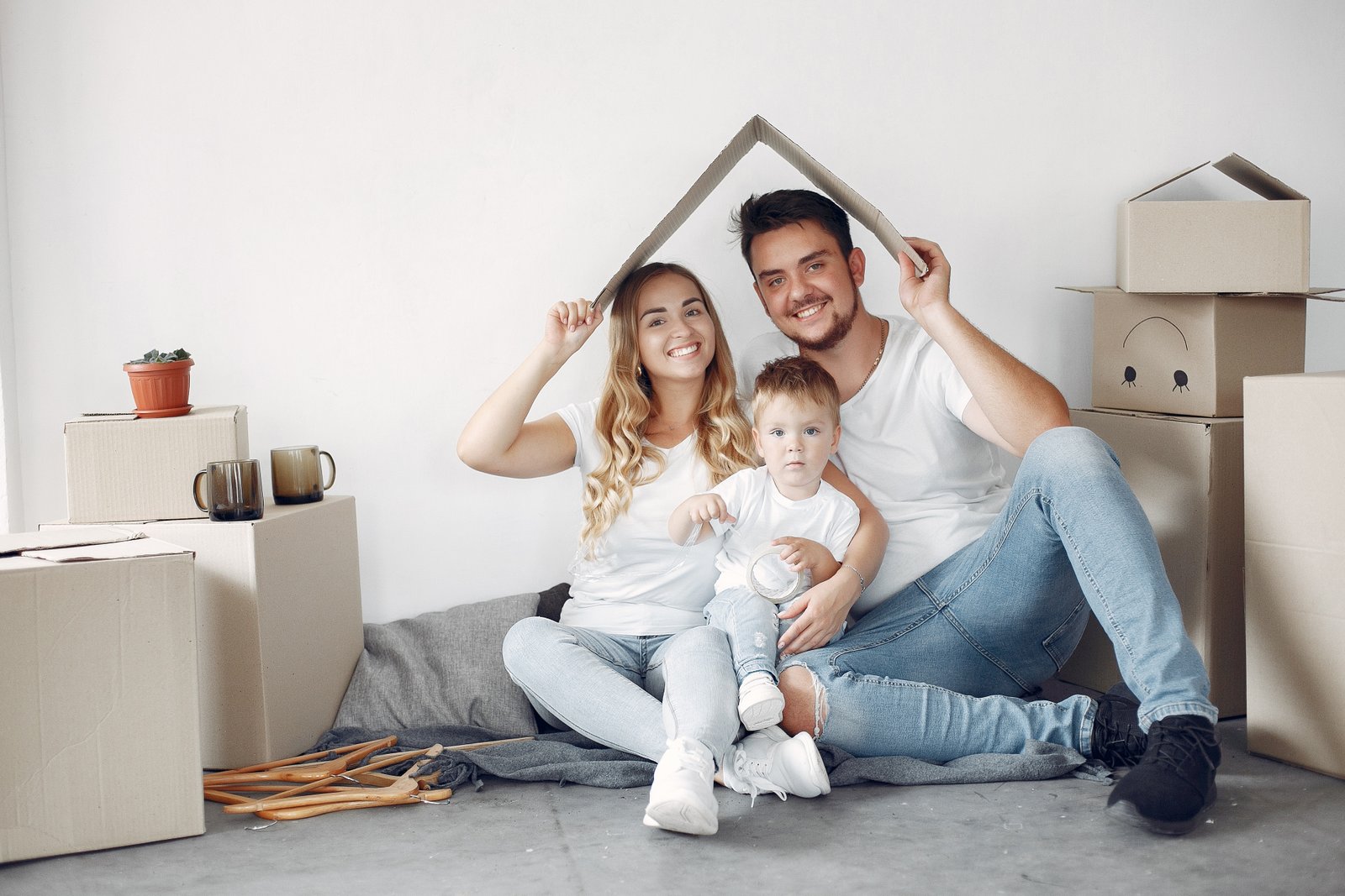 Familia con su hijo entre cajas de mudanza