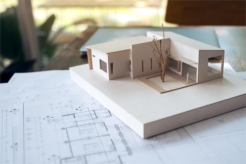 Maqueta de una casa sobre planos de arquitectura
